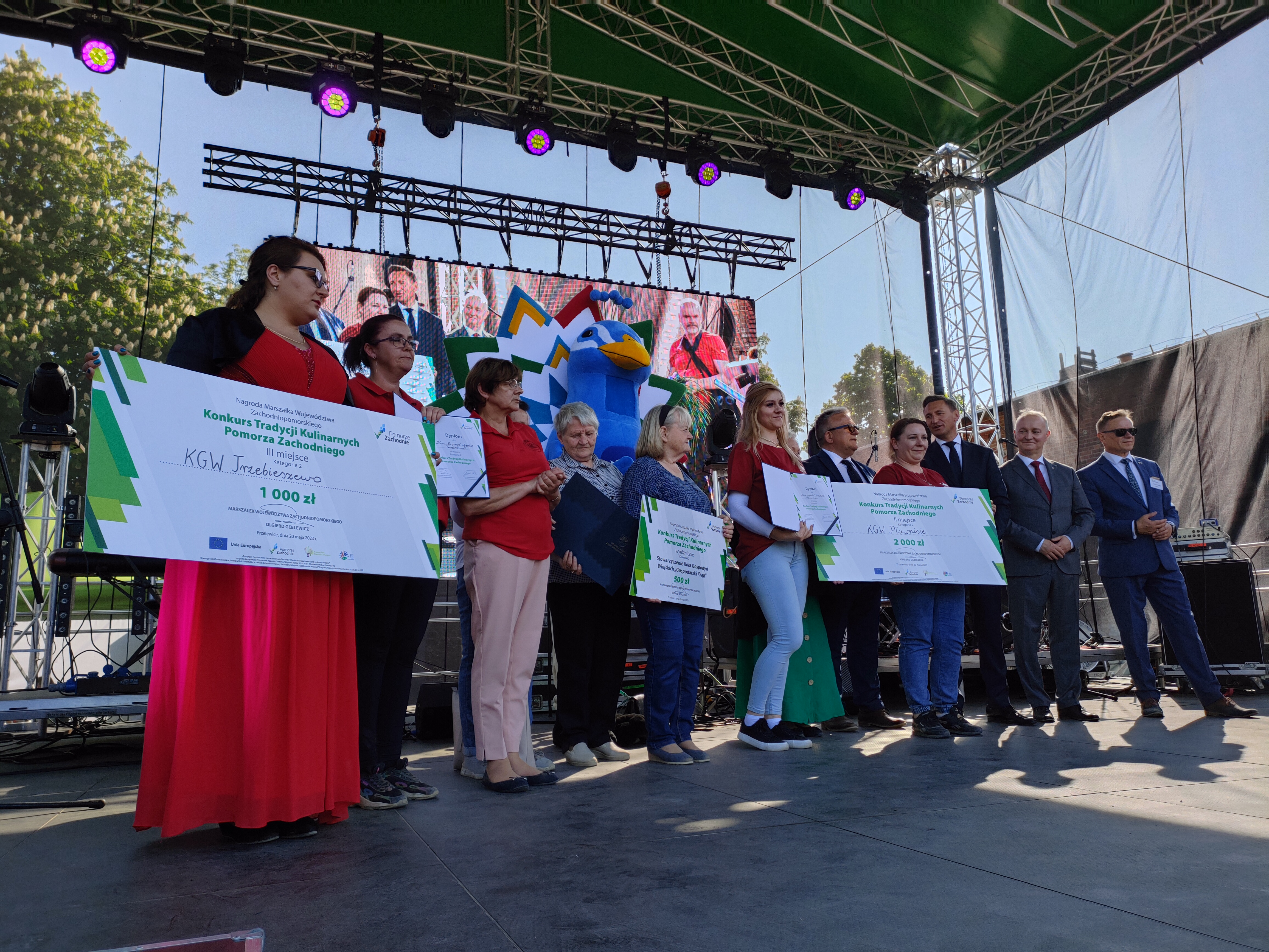 Ludzie stojący na scenie podczas ogłoszenia wyników