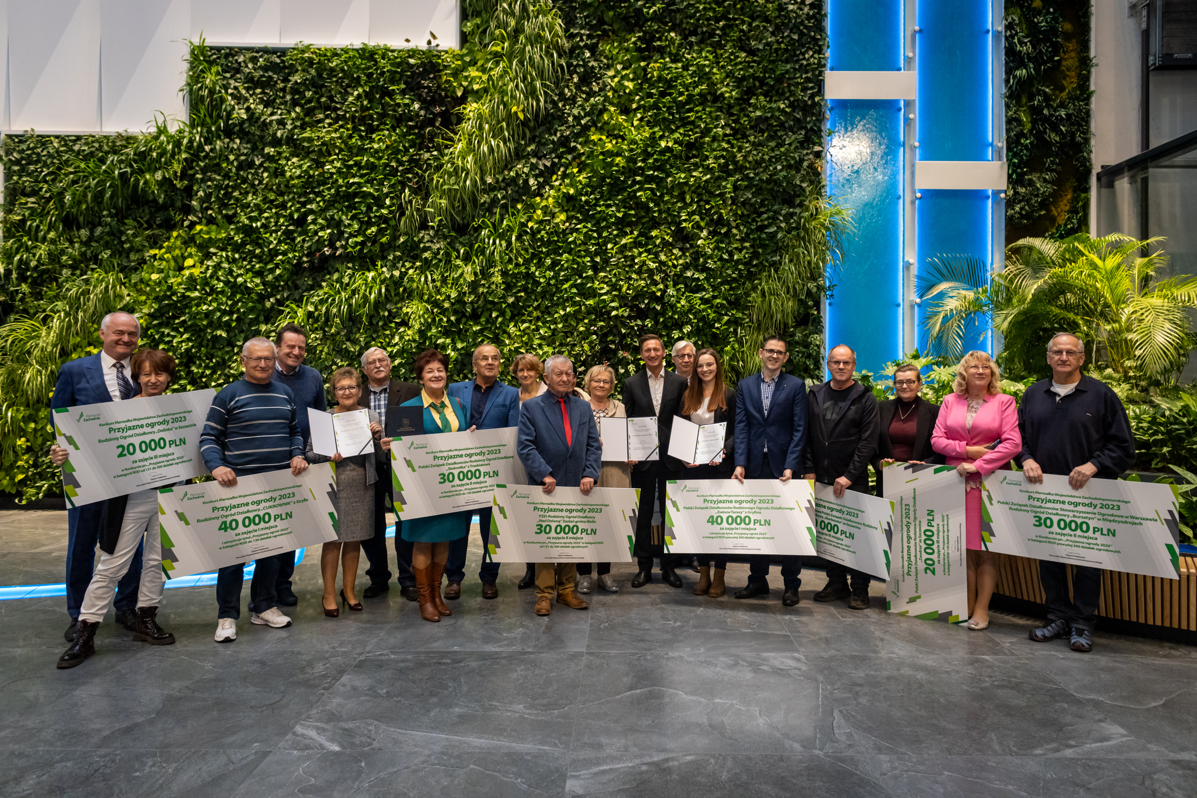 zdjęcie grupowe wszytskich nagrodzonych w konkursie, w dłoniach trzymają czeki
