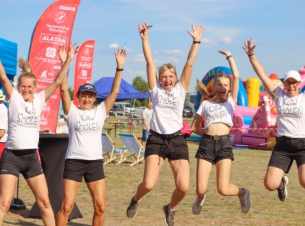 na zdjęciu widać 5 uśmiechnietych kobiet, wykonują podskok z rekoma uniesionymi do góry. Ubrane są w białe koszulki z napisem kgw smoleń